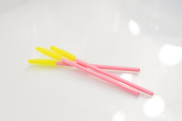 Brushes for eyebrows and eyelashes.  Disposable brushes for eyebrows and eyelashes. Colored brushes pink and yellow