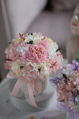 A litlle bouquet with roses, hydrangea. Stabilized flowers in a ceramic vase at home on the dressing table. Interior decor.