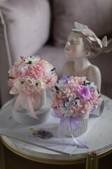 A litlle bouquet with roses, hydrangea. Stabilized flowers in a ceramic vase at home on the dressing table. Interior decor.