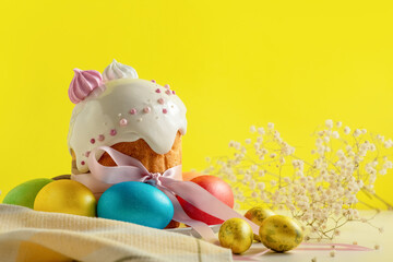 Easter cakes, traditional multi-colored eggs on the festive table, on a yellow background