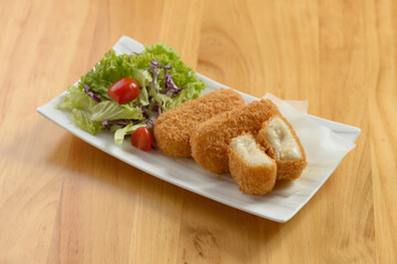 japanese food ceispy Kani Korokke with tomato and salad in white tray on wooden background top view