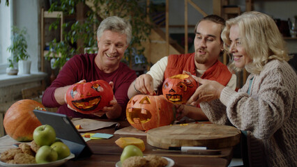  A young man and his parents are making a video of their Halloween pumpkins