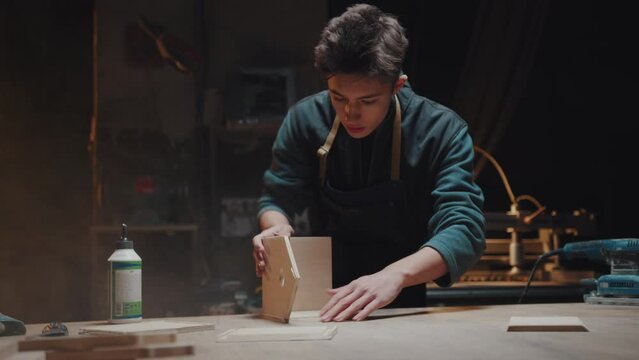 The master constructs wooden houses for animals in his workshop. Hobby and passion, professional carpenter is busy with his work in the garage