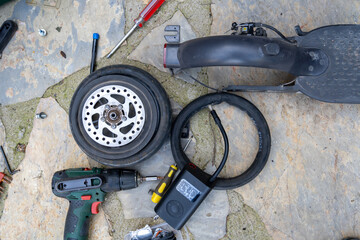 Electric scooter bicycle (Bike) wheel, tire repair. Inflating the tire with an electric air pump to find the puncture before patching with the repair kit.