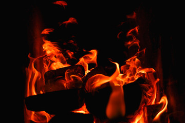 Fire. Photo of flames devouring firewood in a stone fireplace. The texture of the fire in the fireplace. Burning wood inside traditional oven