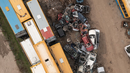 Rusty cars and busses in the junkyard waiting to be dismantled and scrapped