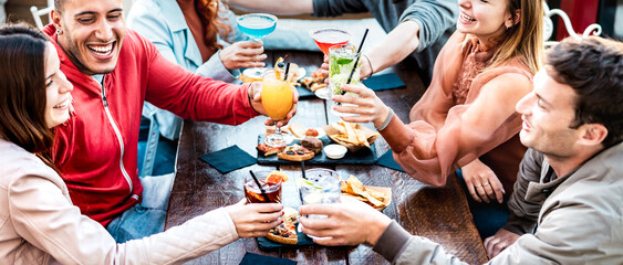 Young people holding multicolored drinks - Trendy fashion friends having fun together toasting...