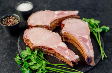 smoked pork steaks on the bone on a stone background