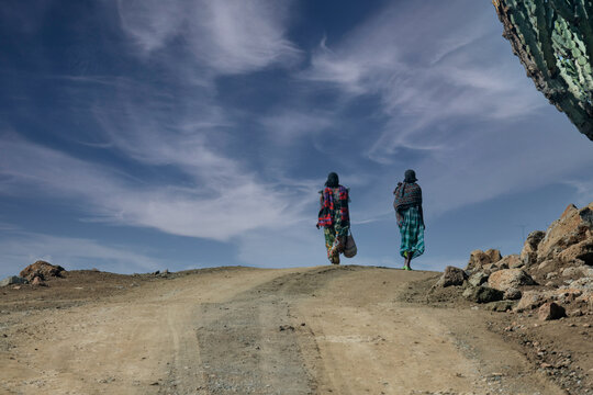 Rural woman walking on a dusty road in Ethiopia