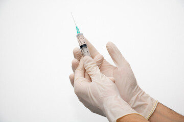 Doctor hand with disposable glove holding liquid drug in syringe with needle on white background.