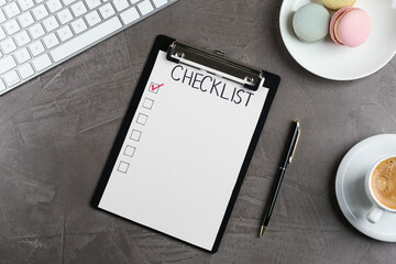 Clipboard with inscription Checklist, cup of coffee, computer keyboard and macarons on grey table, flat lay