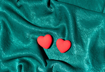 Two hearts on turquoise satin. Flat lay. Minimal love concept for Valentine's Day
