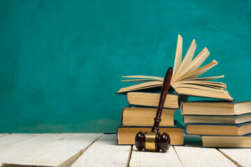 Legal Law and Justice concept - Open law book with a wooden judges gavel on table in a courtroom or...