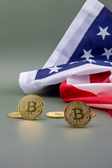 US flag behind some bitcoins, on a green table. 
