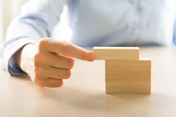 Plan and strategy in business, Risk To Make Business Growth Concept With Wooden Blocks, hand of man has piling up and stacking a wooden block.