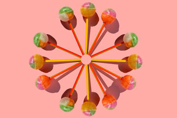 unusual pattern made with caramel on a stick on bright pink background. Colorful Set of Lollipops. creative pattern. lot of lollipops chupa chups..