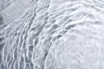 Fototapeta na wymiar Closeup view of water with rippled surface on light background