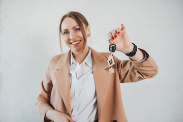 Woman hold keys with house shape keychain. Real estate agent sold new flat. Investing in buyng new property.