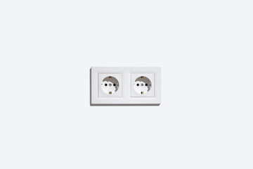 Two sockets in a white frame on a white wall.