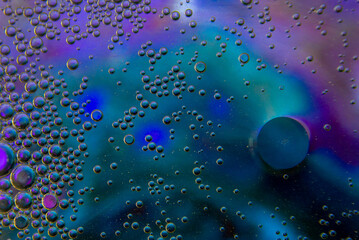 Bubbles in oil in water on blue, turquoise and purple colour abstract background
