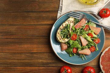 Delicious pomelo salad with grilled avocado served on wooden table, flat lay. Space for text