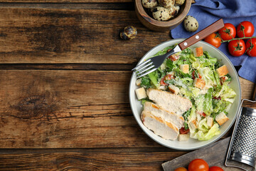 Delicious Caesar salad in bowl on wooden table, flat lay. Space for text - obrazy, fototapety, plakaty
