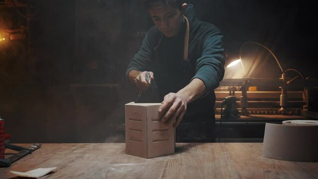 The carpenter guy blows dust off the finished wooden product, a house for birds and animals. Carpentry training