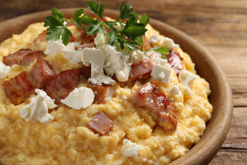 Delicious traditional Ukrainian banosh in bowl on wooden table, closeup