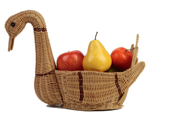 A wicker basket in the form of a swan with fruit.