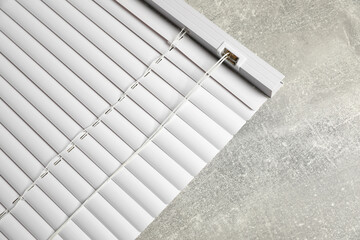 Obraz premium Stylish horizontal window blinds on grey table, top view