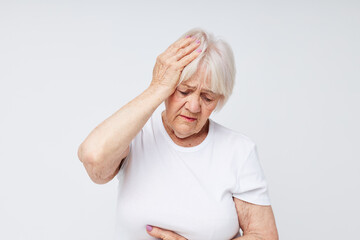 elderly woman in a white t-shirt headache health problems cropped view