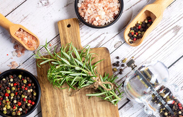 Composition with different spices,rosemary ,himalayan salt and wooden spoons on wooden background