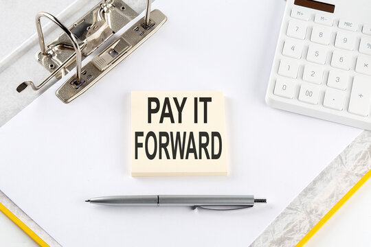 PAY IT FORWARD - business concept, message on the sticker on folder background with calculator