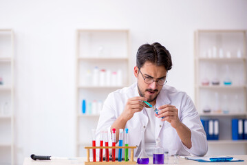Young male chemist working at the lab