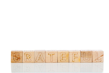 Wooden cubes with letters gratrful on a white background