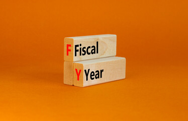FY Fiscal year symbol. Concept words FY Fiscal year on wooden blocks on a beautiful orange table...