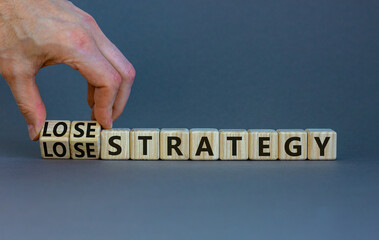 Lose-lose strategy symbol. Businessman turns wooden cubes with words lose lose strategy. Beautiful grey table, grey background. Business, lose-lose strategy concept. Copy space.