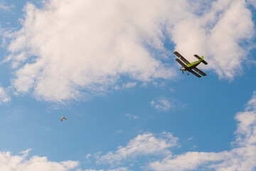Green biplane, retro airplane flying in blue sky and doing stunts at Air Show. Performance, extreme, aerobatic, sport and aircraft concept