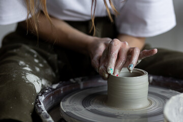 Young woman doing handmade pottery on the potter's wheel. Artist at work