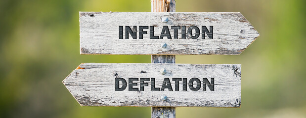 opposite signs on wooden signpost with the text quote inflation deflation engraved. Web banner format.