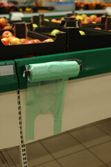 Plastic bags near crates with fruits in supermarket