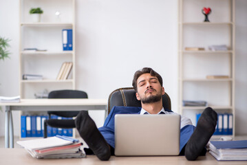 Young male employee extremely tired in the office