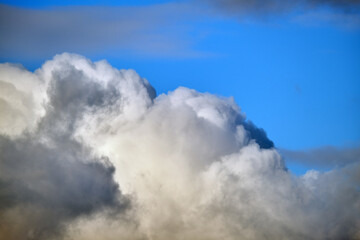 Bright landscape of white puffy cumulus clouds on blue clear sky