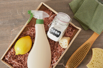 soda in a jar, spray bottle, lemon and other cleaning products in a box
