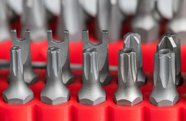 Closeup of steel secure torx or pozidrive screwing bits in red plastic holder. Set of varied sized...