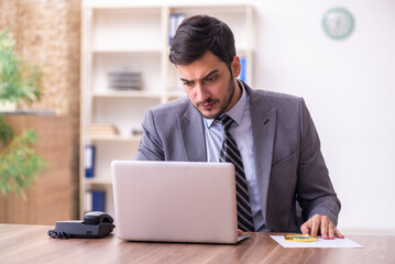 Young handsome businessman employee working in the office