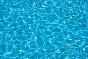 Fototapeta na wymiar Closeup surface of blue clear water with small ripple waves in swimming pool