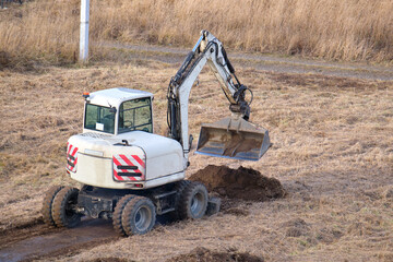 Fototapeta na wymiar Earth moving tractor preparing place for future house foundation construction. Leveling soil for building new home