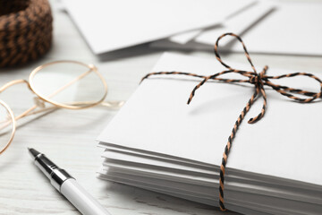 Letters, pen and glasses on white wooden table, closeup