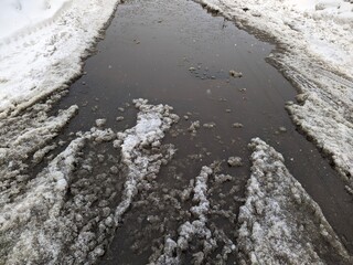 melted dirty snow on city streets photo in the daytime.